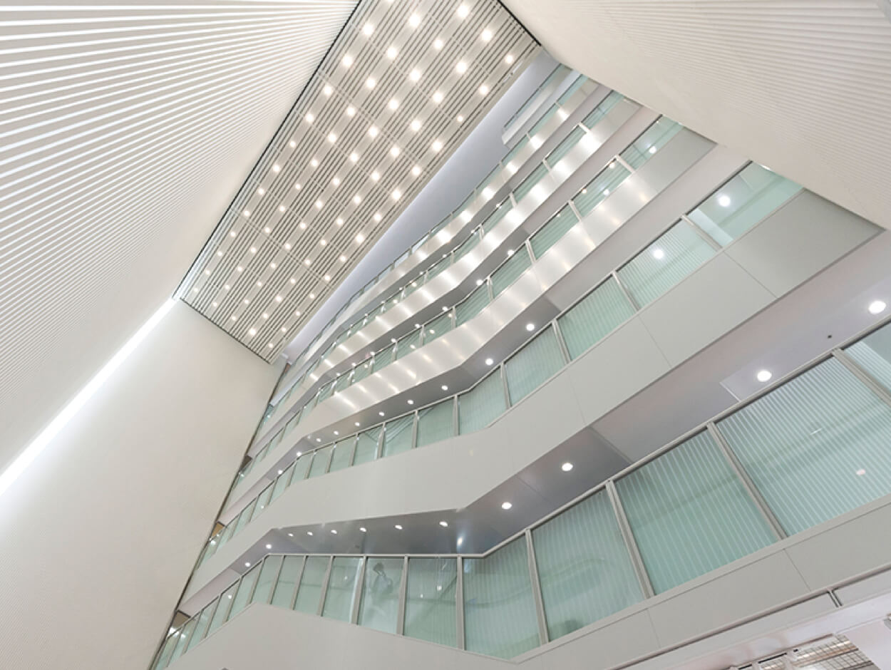 The iconic multi-story atrium at Matsuya Ginza, a signature feature since its opening, with bright lighting, glass railings, and white interior walls.
