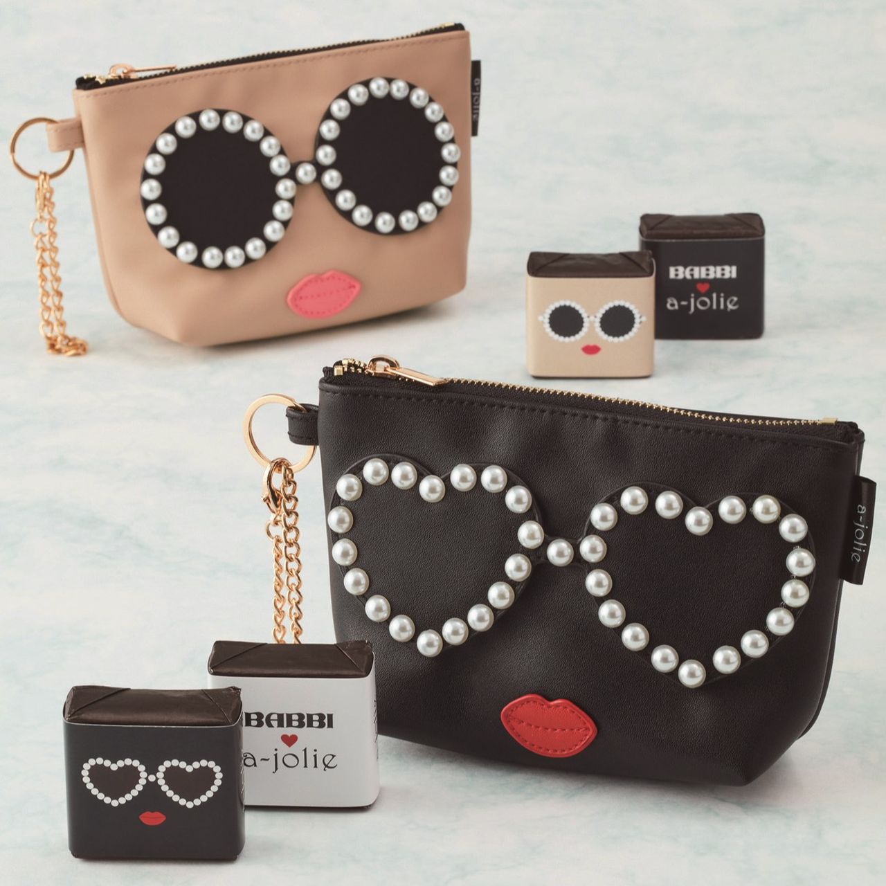 Two stylish pouches with pearl-studded glasses and red lips designs. Accompanied by small square accessories on a light background.