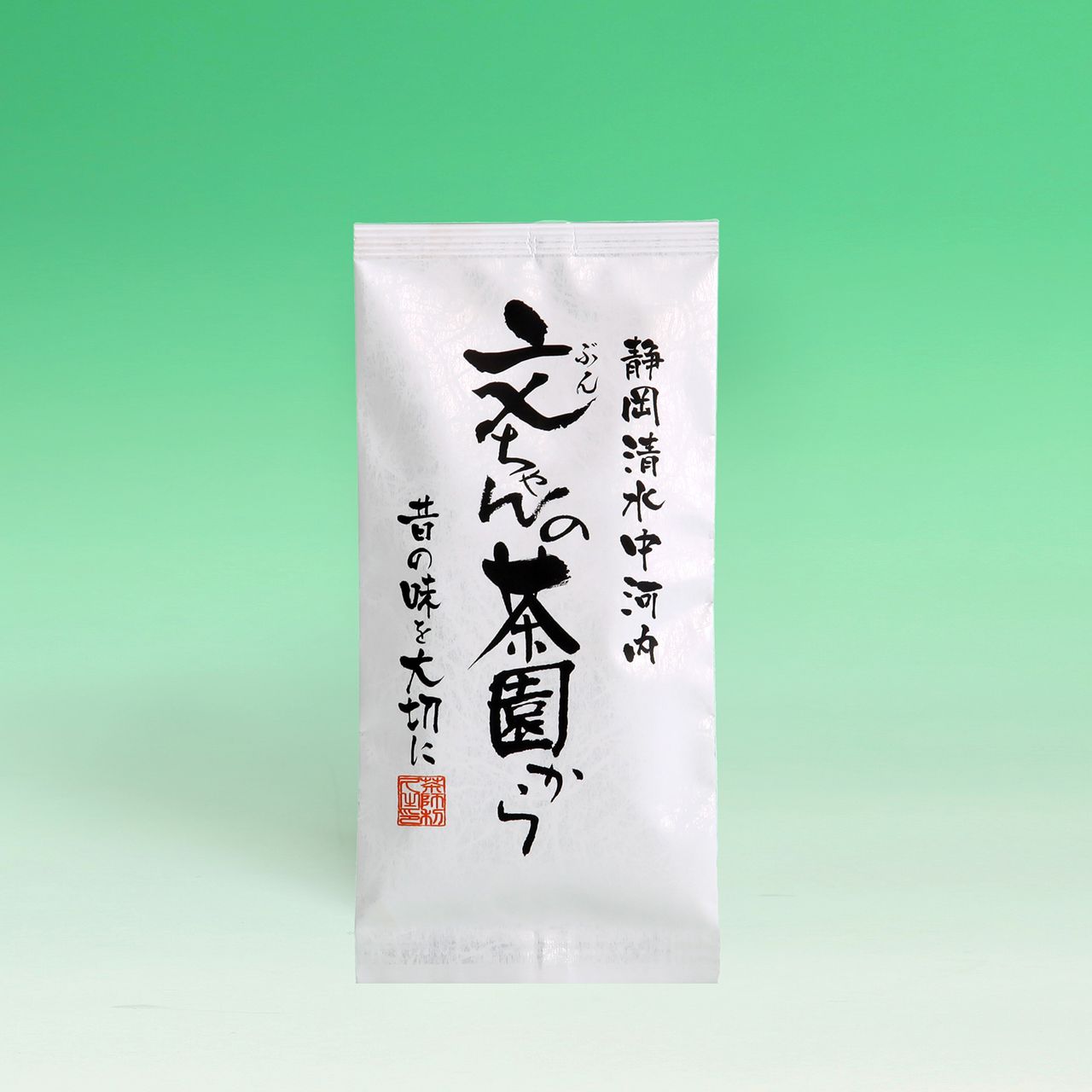 A white tea package with Japanese calligraphy on a gradient green background. A red seal stamp is near the bottom left.