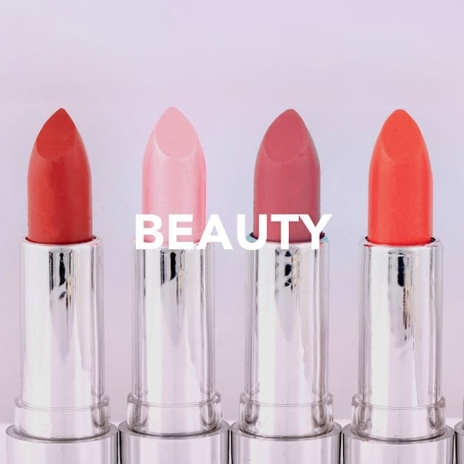Four lipsticks in red, pink, mauve, and coral shades with the word "BEAUTY" overlaid on a light background.