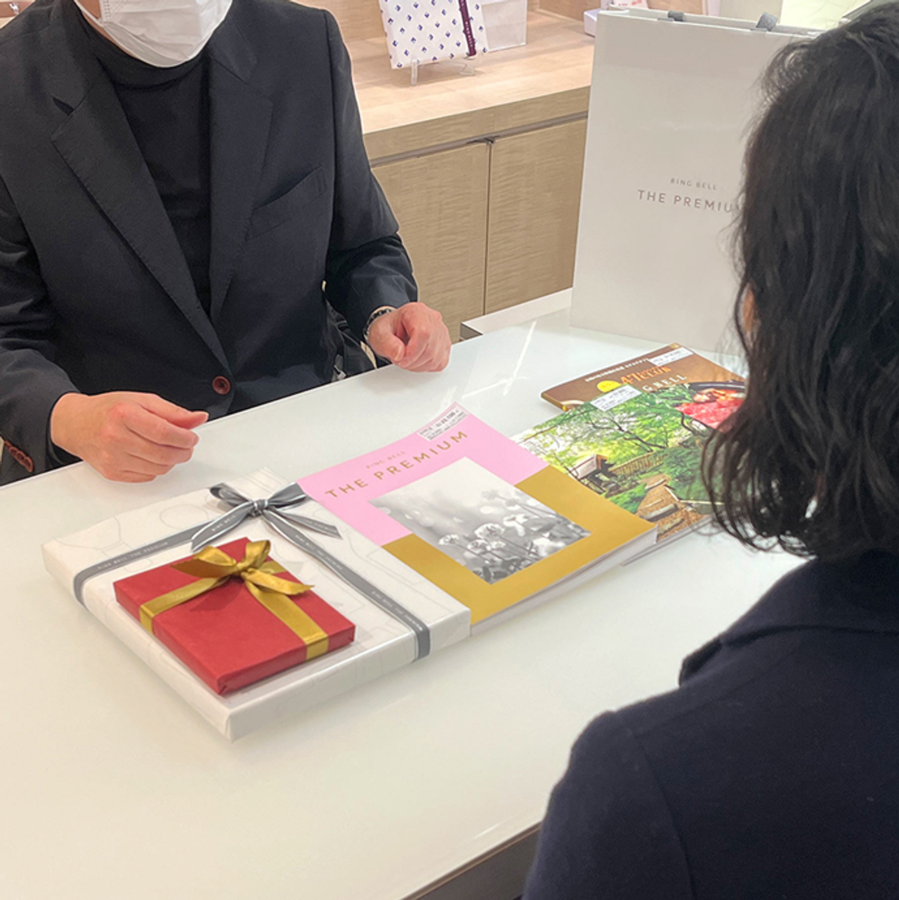 松屋銀座の専任コンシェルジュが、お客様のご要望に寄り添いながらカタログギフトのご提案を丁寧に行っている様子。