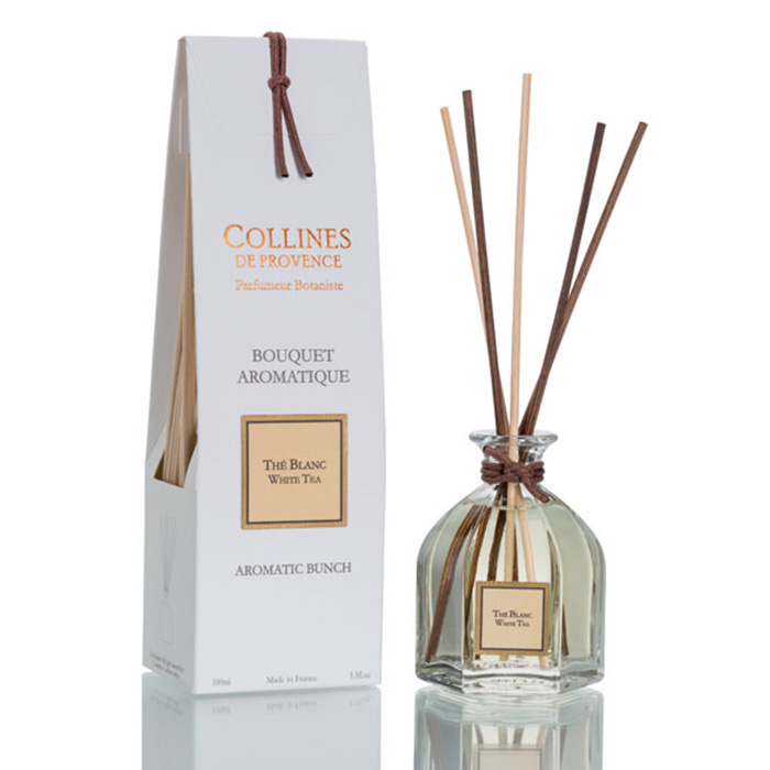 Aromatic diffuser set with a glass bottle labeled "Thé Blanc" and brown reeds, next to a white box labeled "Bouquet Aromatique."